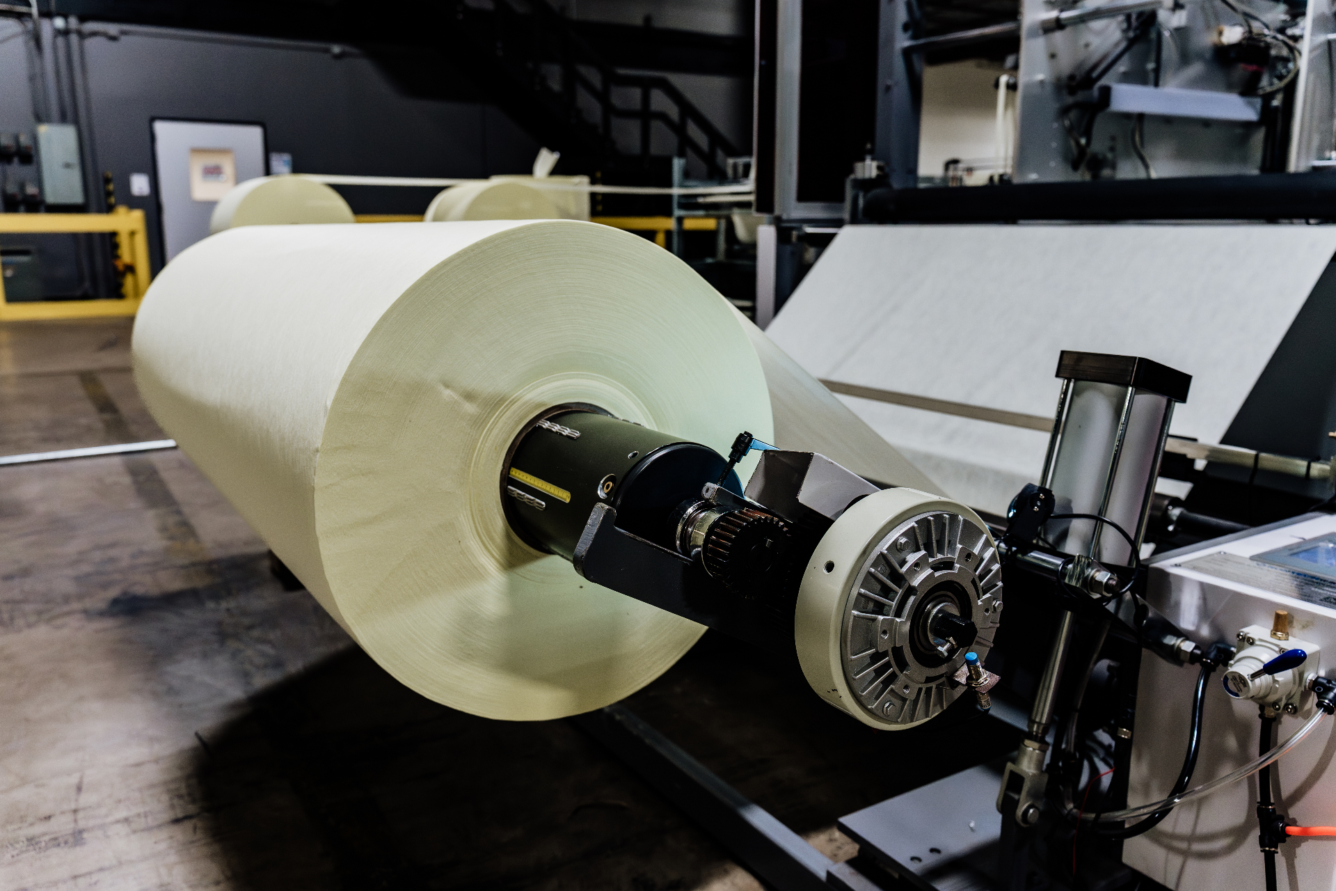 Close-up of a nonwoven gown-stock roll mounted on the unwind drive