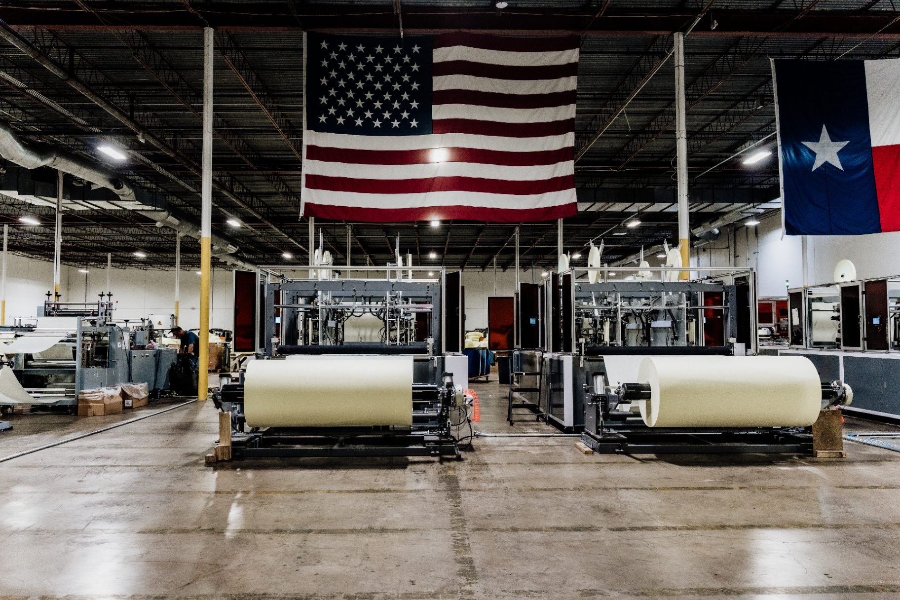 Twin AAMI Level 2 isolation gown manufacturing lines beneath the American flag