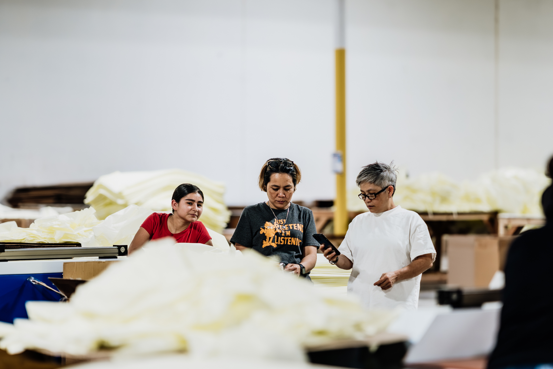 Houston factory workers reviewing gown output on the production floor